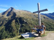 Neben der Bockhartseehütte steht ein Gipfelkreuz - Salesenkogel im Hintergrund