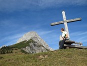 Ein Kreuz nahe der Elmaualm mit Blick auf die Werfener Hütte oberhalb der Latschengrenze